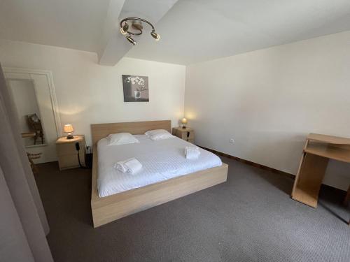 1 dormitorio con 1 cama con sábanas y almohadas blancas en L'Ouvrée, chaleureux en famille ou entre amis, en Saint-Aubin