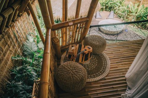 a wooden rocking chair with two balls and a gun at Balikayanas - Ellena House in Karangasem