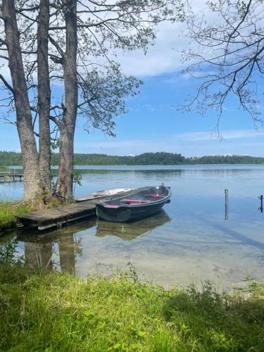una barca parcheggiata al molo su un lago di Rajskie Pluski Slow Life nad jeziorem a Pluski