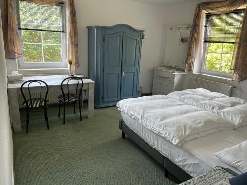 a bedroom with two beds and a desk and a table at Altenmedinger Hof in Altenmedingen