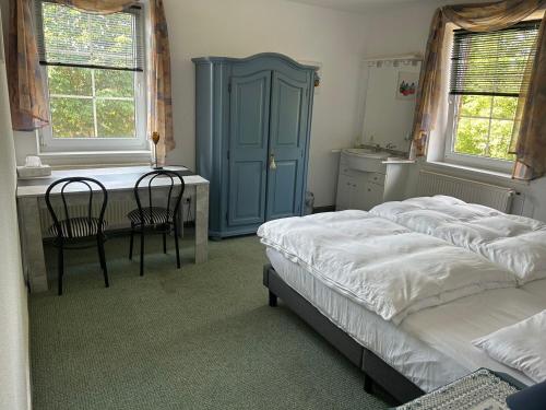 een slaapkamer met 2 bedden, een bureau en een tafel bij Altenmedinger Hof in Altenmedingen
