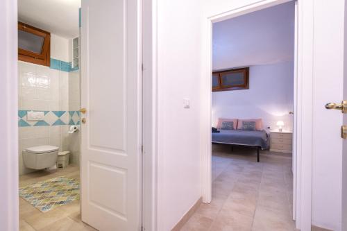 Habitación con dormitorio con cama y puerta en Soleluna apartment en Castelsardo