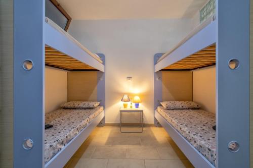 two bunk beds in a room with a table at Soleluna apartment in Castelsardo