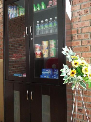 a black cabinet with drinks in it with a bouquet of flowers at JQ BL Hotel, Ipoh in Ipoh