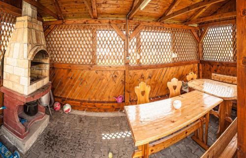 Duży drewniany pokój z drewnianym stołem i kominkiem w obiekcie Dom na okraji obce - Privát Šiškovci w Habówce