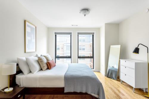 um quarto branco com uma cama e uma janela em Fenway 1BR w Gym steps from Fenway Park BOS-375 em Boston