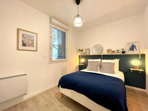 um quarto com uma cama grande e um cobertor azul em Le Jardin - Calme et Confort - Lac de Nantua em Nantua