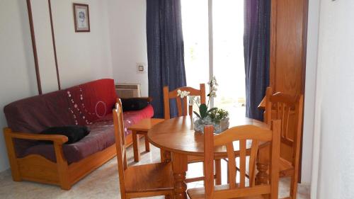 a living room with a table and a couch at Apartamentos Costa Azahar 3000 in Alcossebre