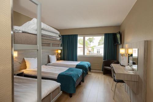 マリエハムンにあるHotel Adlonの二段ベッド2台とテレビが備わるホテルルームです。