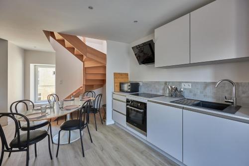 une cuisine et une salle à manger avec une table et des chaises dans l'établissement Maison Andrias - Charmante maison de bourg, à Langrune-sur-Mer