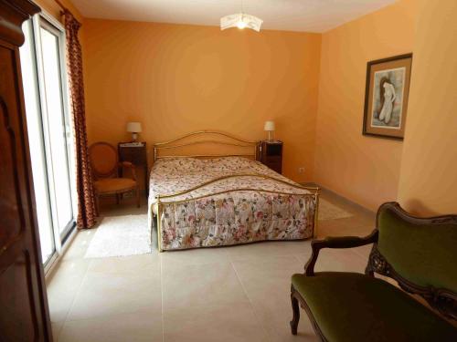 une chambre avec un lit, une chaise et une fenêtre dans l'établissement Villa en Provence Verte, à Carcès