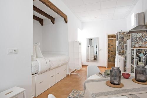 a white room with a bed and a table at Casa de Berta in Vejer de la Frontera