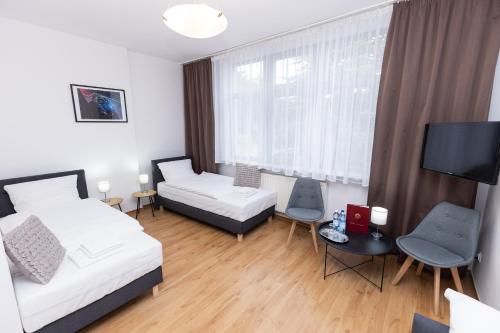 a small room with two beds and a tv at Hotel Tor Kielce in Kielce