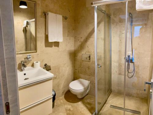 een badkamer met een douche, een toilet en een wastafel bij MAV Boutique Villa in Eforie Nord