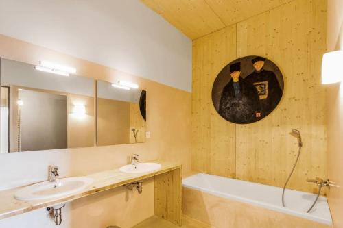 une salle de bain avec deux lavabos, une baignoire et un miroir dans l'établissement Une des plus belles vues de la Drôme, à Teyssières