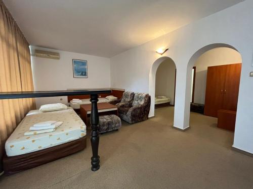 a hotel room with a bed and a chair at Апарт Хотел Мари in Ravda