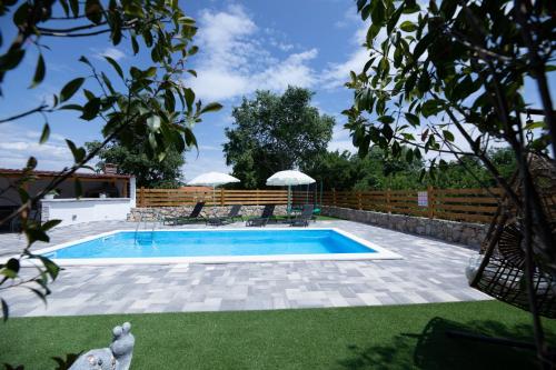 a swimming pool with two chairs and a fence at Villa Meri in Gabonjin