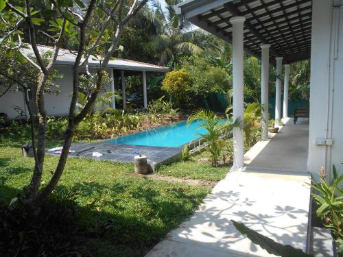 una piscina en un patio junto a una casa en South House-Weligama, en Weligama