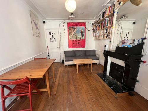 - un salon avec une table et un piano dans l'établissement Apartment near Montmartre(2 rooms!), à Paris