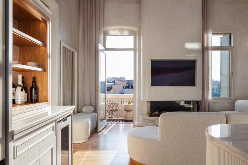 sala de estar con TV y sala de estar con sofá en La Torre Residenza Imperiale en La Canea