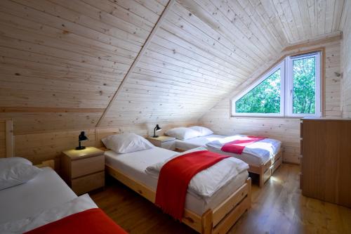a room with three beds in a log cabin at Domki Nadmorski Skarb Ostrowo k/Karwi in Ostrowo