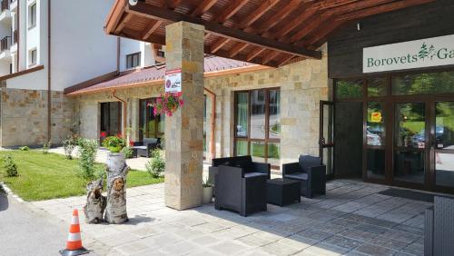 a building with a dog sitting in front of it at Pinewood ANG luxurious apartment A43, Borovets Gardens in Borovets