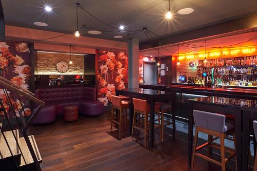 a bar with chairs and a couch in a room at Malmaison London in London