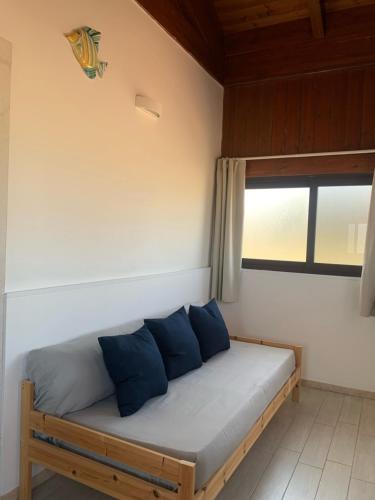 uma cama com almofadas azuis num quarto com uma janela em Spiaggia Le Dune Residence em Margherita di Savoia