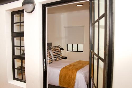 a bedroom with a bed and a mirror at Hermanus Champagne Accommodation in Hermanus