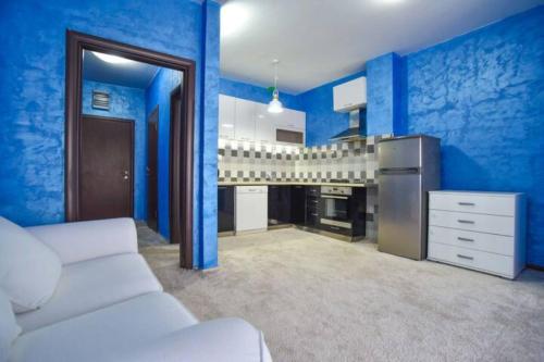 uma sala de estar com paredes azuis e um sofá branco em Redondo Apartments Budva em Budva