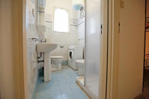 La salle de bains est pourvue d'un lavabo, de toilettes et d'une fenêtre. dans l'établissement Residence Miami, à Lido di Spina