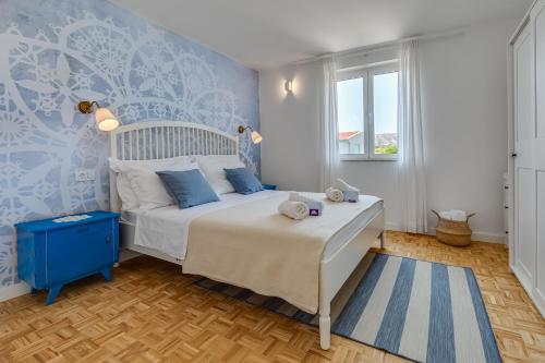 ein Schlafzimmer mit einem Bett und einer blauen Wand in der Unterkunft Villa Silencia in Pag