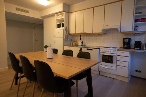 una cucina con tavolo e sedie in legno di Koivikko Lifestyle Center a Mikkeli