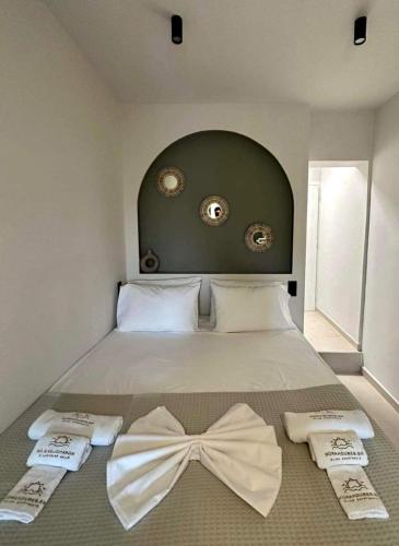 a bedroom with a bed with a bow tie on it at Mora Houses in Mandrakia