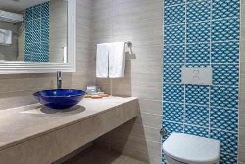 ein Badezimmer mit einem blauen Waschbecken und einem WC in der Unterkunft Paloma Oceana in Side