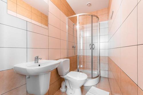 ein Bad mit einem WC, einem Waschbecken und einer Dusche in der Unterkunft Domki i pokoje POD KOGUTEM - kwatery prywatne in Stegna