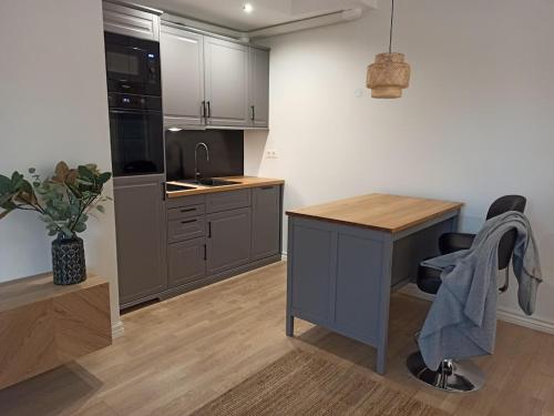 een keuken met grijze kasten en een bureau met een stoel bij Self check in apartment with terrace in Pärnu