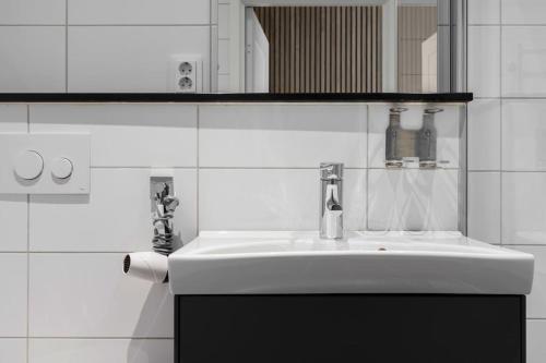 een witte badkamer met een wastafel en een spiegel bij Tott studios in Åre