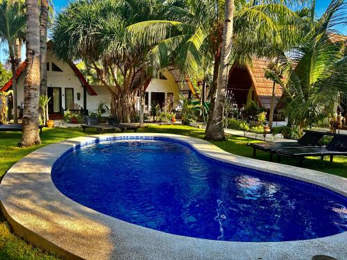 a swimming pool in a yard with palm trees at Gili Land in Gili Air