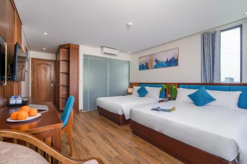 Cette chambre comprend 2 lits et une table. dans l'établissement Sea Wind Hotel by THG, à Đà Nẵng