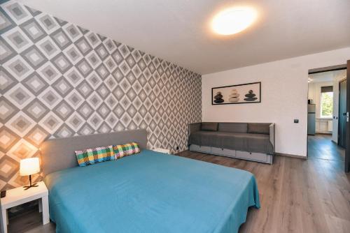 a bedroom with a blue bed and a couch at King Petera in Ventspils