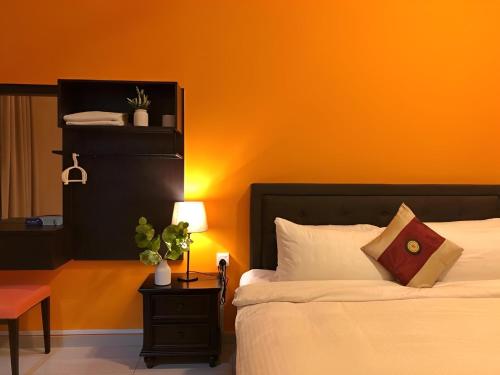 a bedroom with a bed with an orange wall at Malacca City Center Town House by 360HOME in Melaka