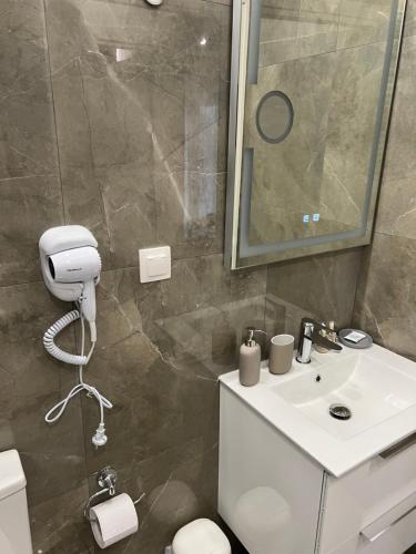 y baño con lavabo, aseo y espejo. en KM51 luxury apartments en Tesalónica