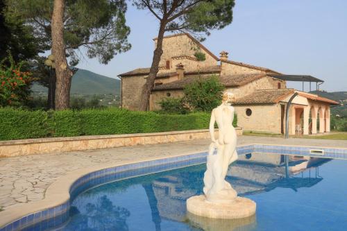una statua è in piedi accanto a una piscina di Palombara Country House a Montecchio