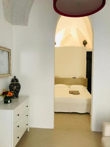 a bedroom with a bed and a white wall at La Casa di Bacco B&b in Alezio