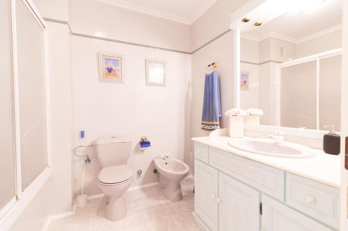 uma casa de banho branca com um WC e um lavatório em Global Properties, Acogedor adosado en la playa de Corinto em Sagunto
