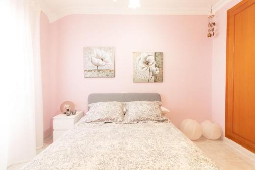 um quarto com uma cama e três fotografias na parede em Global Properties, Acogedor adosado en la playa de Corinto em Sagunto