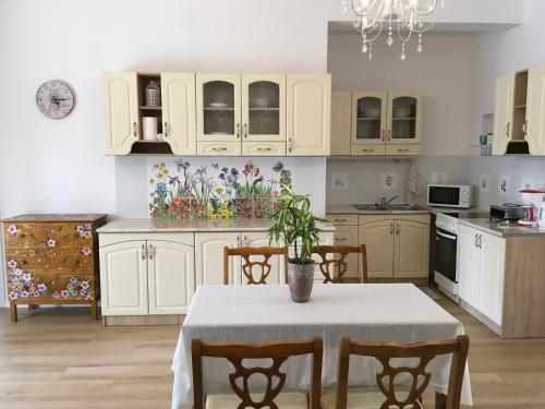 una cocina con armarios blancos y una mesa con una planta. en Villa Rosa Centre, en Balatonfüred