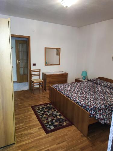 a bedroom with a bed and a desk and a mirror at Casa Sartori in Caderzone Terme