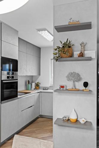 a kitchen with white cabinets and black appliances at Apartment Leone Medulin in Medulin